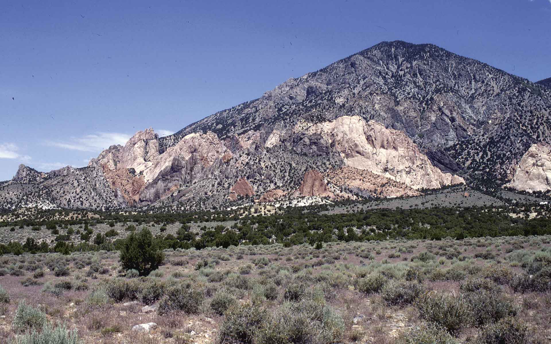 The diorite porphyry laccolithic intrusion of Mount Hillers, southern Henry Mountains, Utah, is surrounded by upturned beds of strata and interleaved diorite sills dipping 75°–85°.