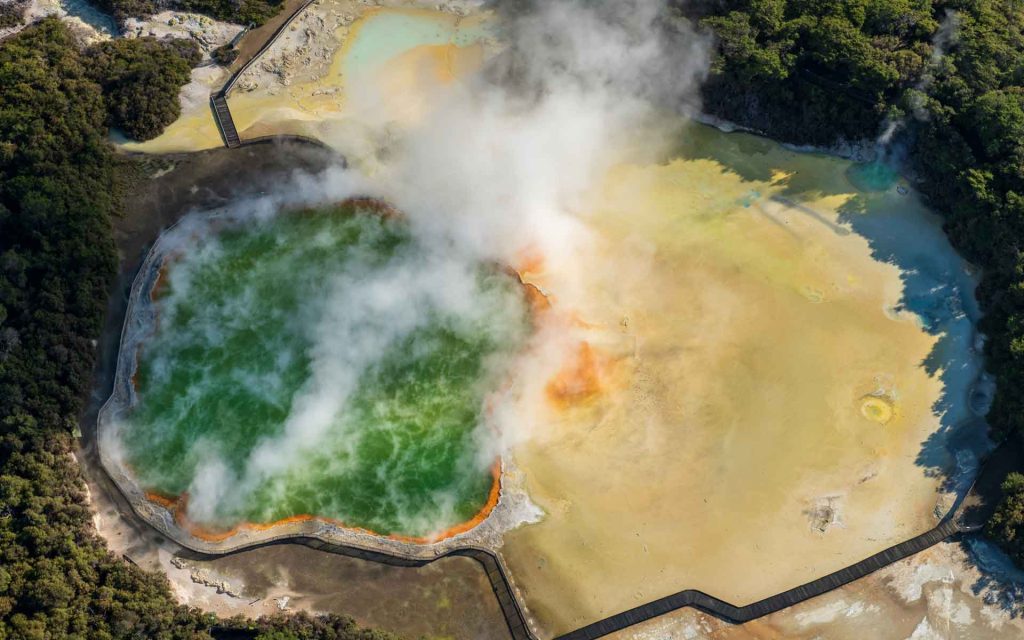 Waiotapu's Champagne Pool (left), with orange sinter rim, and Artist's Palette sinter terrace (right) are among the most colourful geothermal features globally. Photo: Alastair Jamieson.