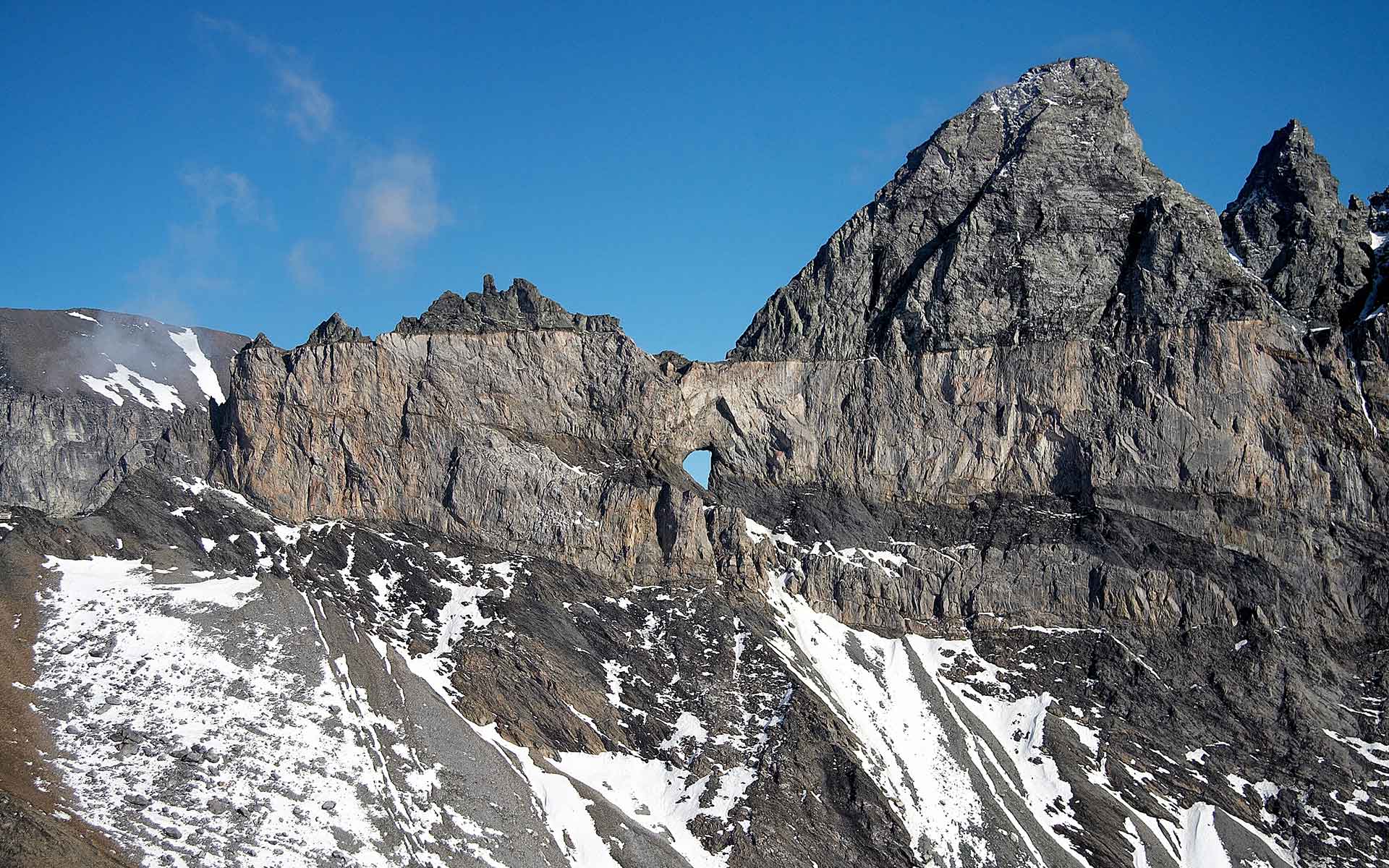 Famous view of Tschingelhörner with Martin’s Hole. The Glarus thrust is visible as a line along the cliff where the rock changes color.