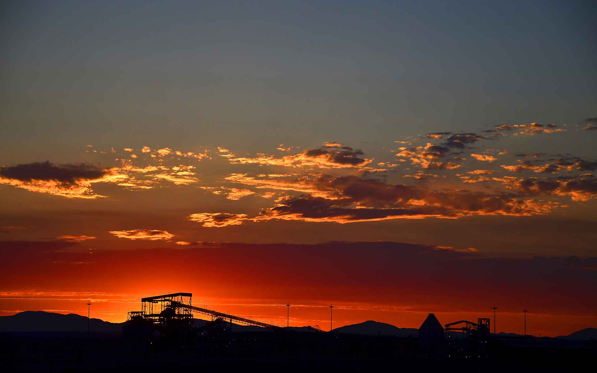 Sunset in the Kalahari Manganese Field with the silhouette of the N'Chwaning manganese mine in the foreground.